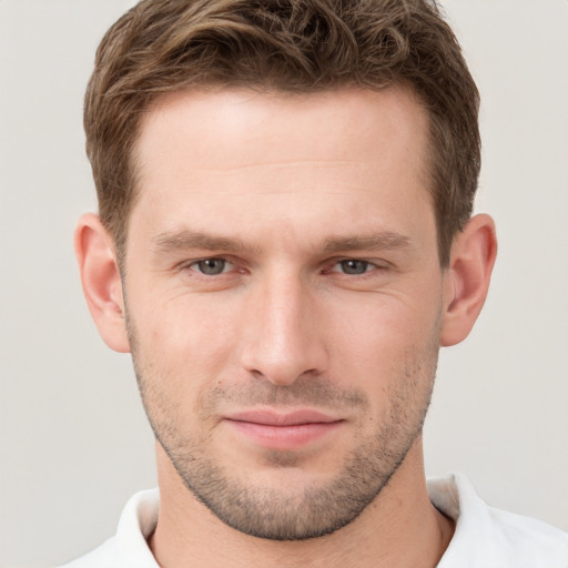 Joyful white young-adult male with short  brown hair and grey eyes