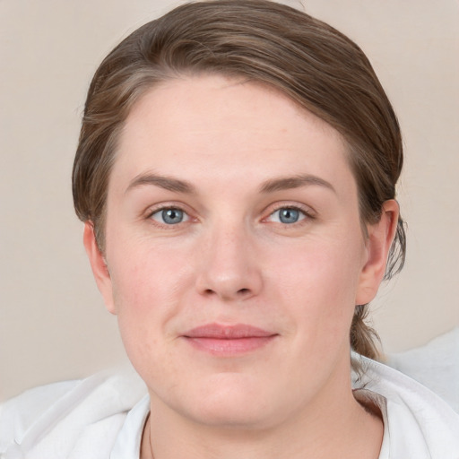 Joyful white young-adult female with short  brown hair and blue eyes