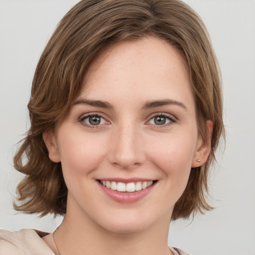 Joyful white young-adult female with medium  brown hair and green eyes