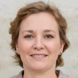 Joyful white young-adult female with medium  brown hair and blue eyes