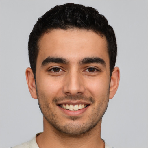 Joyful latino young-adult male with short  brown hair and brown eyes