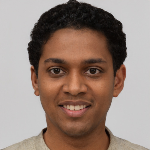 Joyful black young-adult male with short  black hair and brown eyes