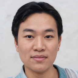 Joyful asian young-adult male with short  black hair and brown eyes