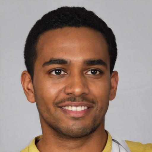 Joyful black young-adult male with short  black hair and brown eyes