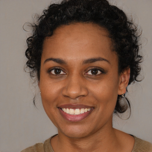 Joyful black young-adult female with medium  brown hair and brown eyes