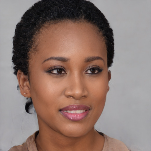 Joyful black young-adult female with short  brown hair and brown eyes