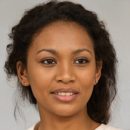 Joyful black young-adult female with long  brown hair and brown eyes