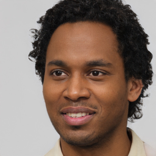Joyful black young-adult male with short  brown hair and brown eyes