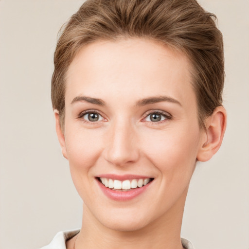 Joyful white young-adult female with short  brown hair and grey eyes