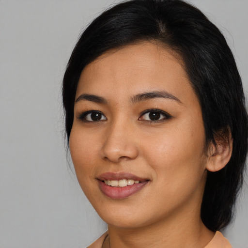 Joyful asian young-adult female with long  black hair and brown eyes