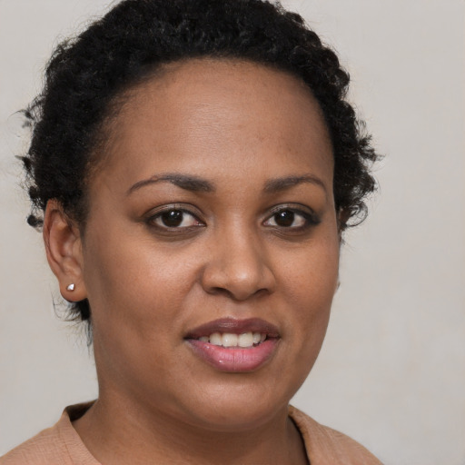 Joyful black young-adult female with short  brown hair and brown eyes