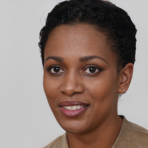 Joyful black young-adult female with short  black hair and brown eyes