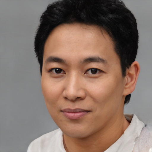 Joyful asian young-adult male with short  black hair and brown eyes