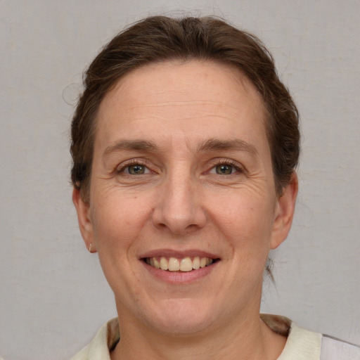 Joyful white adult female with short  brown hair and grey eyes