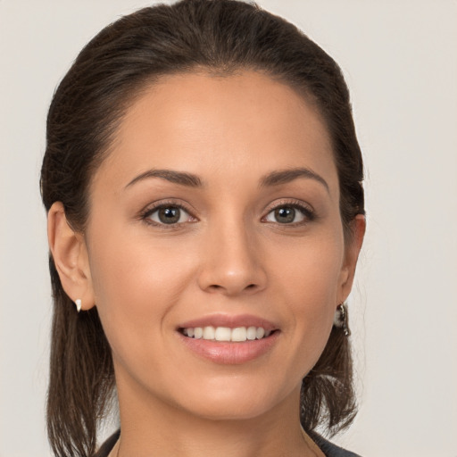 Joyful white young-adult female with long  brown hair and brown eyes