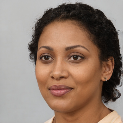 Joyful black adult female with medium  brown hair and brown eyes