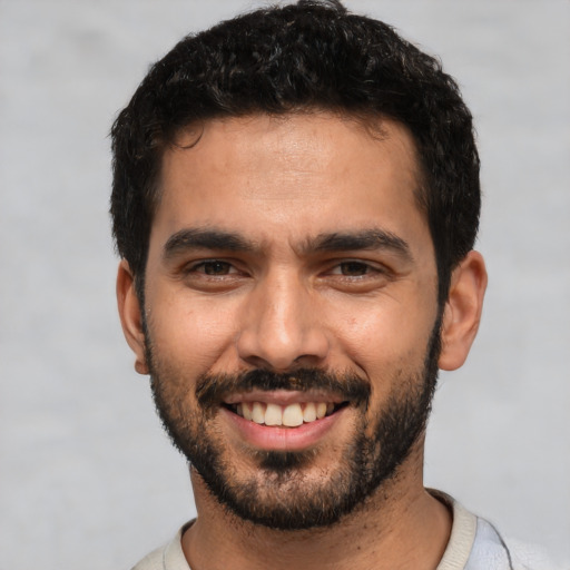 Joyful white young-adult male with short  black hair and brown eyes