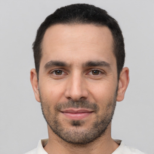 Joyful white young-adult male with short  black hair and brown eyes