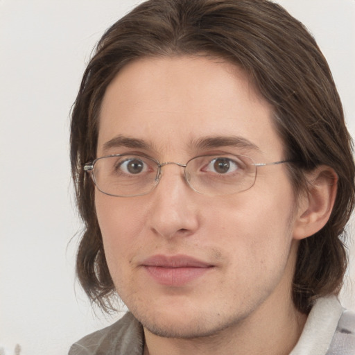 Joyful white young-adult male with medium  brown hair and grey eyes