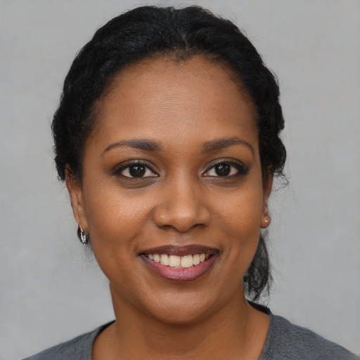 Joyful black young-adult female with short  black hair and brown eyes