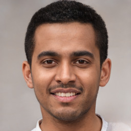 Joyful latino young-adult male with short  brown hair and brown eyes