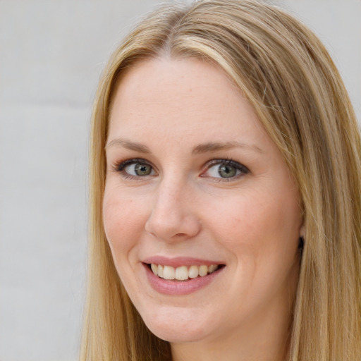 Joyful white young-adult female with long  brown hair and blue eyes