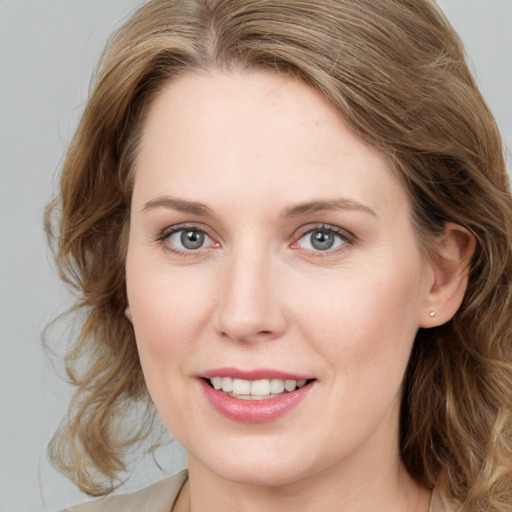 Joyful white young-adult female with medium  brown hair and blue eyes