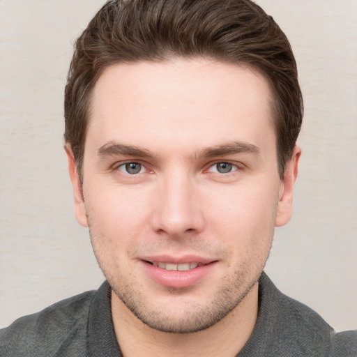 Joyful white young-adult male with short  brown hair and grey eyes