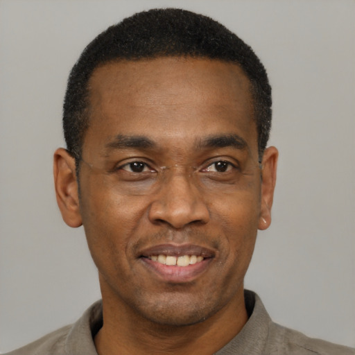 Joyful black adult male with short  black hair and brown eyes
