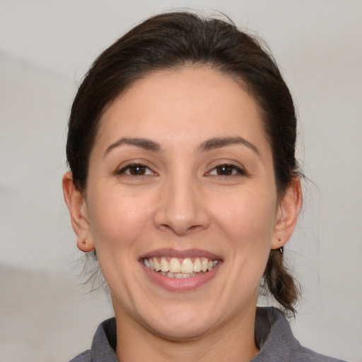 Joyful white adult female with medium  brown hair and brown eyes