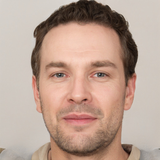 Joyful white adult male with short  brown hair and brown eyes