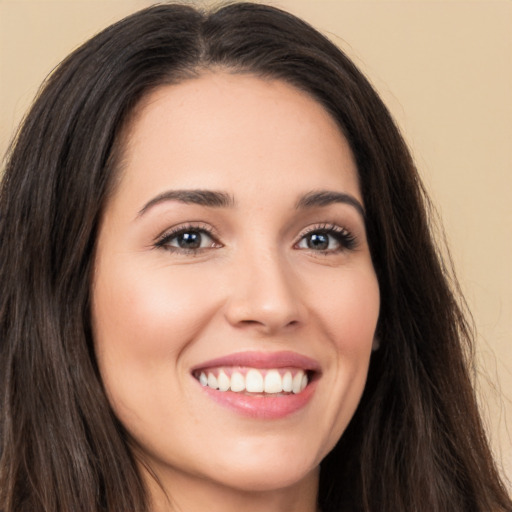 Joyful white young-adult female with long  brown hair and brown eyes