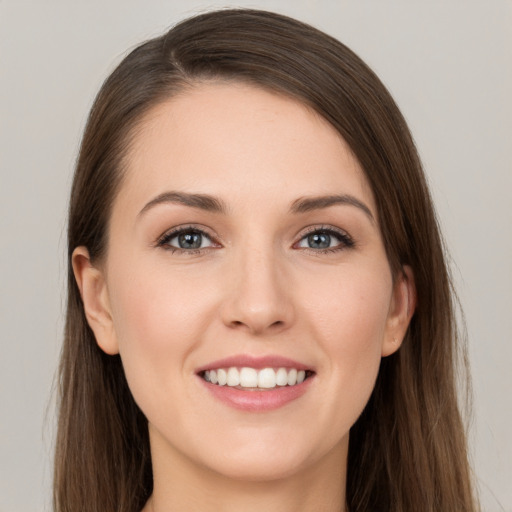 Joyful white young-adult female with long  brown hair and grey eyes