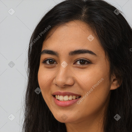 Joyful latino young-adult female with long  brown hair and brown eyes