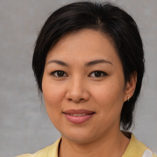 Joyful asian young-adult female with medium  brown hair and brown eyes