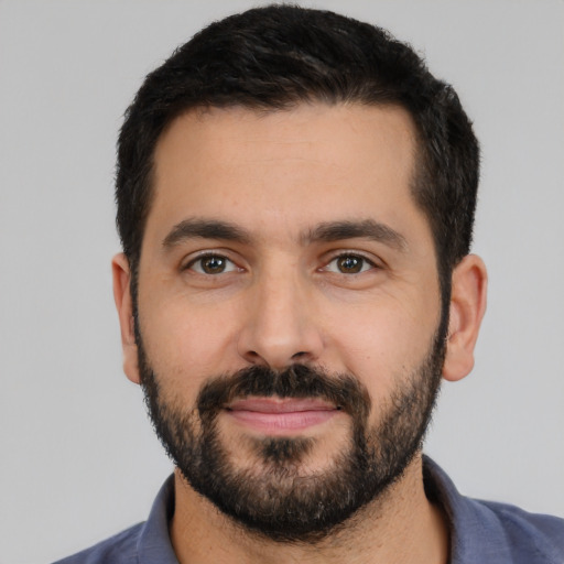 Joyful latino young-adult male with short  black hair and brown eyes