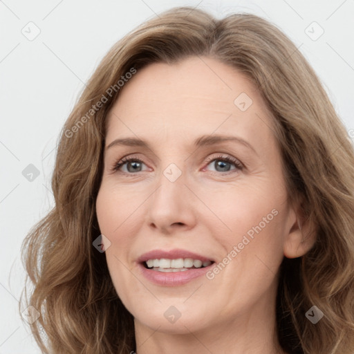 Joyful white adult female with long  brown hair and grey eyes