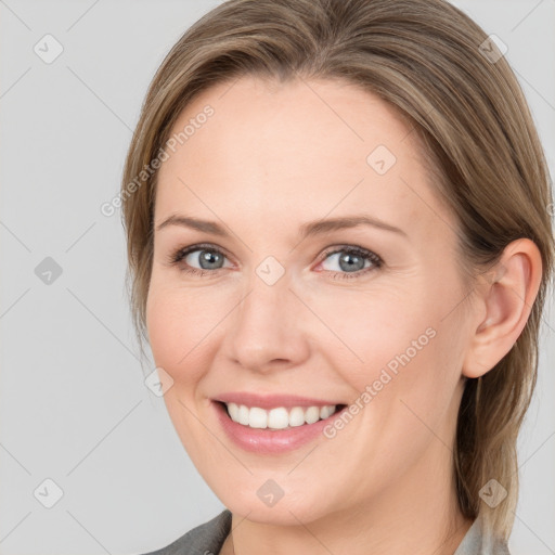 Joyful white young-adult female with medium  brown hair and grey eyes