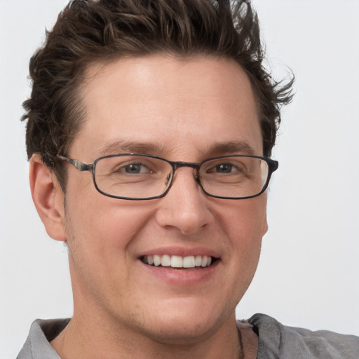 Joyful white adult male with short  brown hair and grey eyes