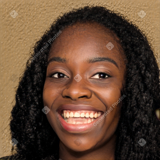 Joyful black young-adult female with long  black hair and brown eyes