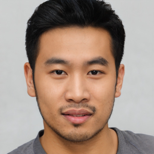 Joyful asian young-adult male with short  black hair and brown eyes