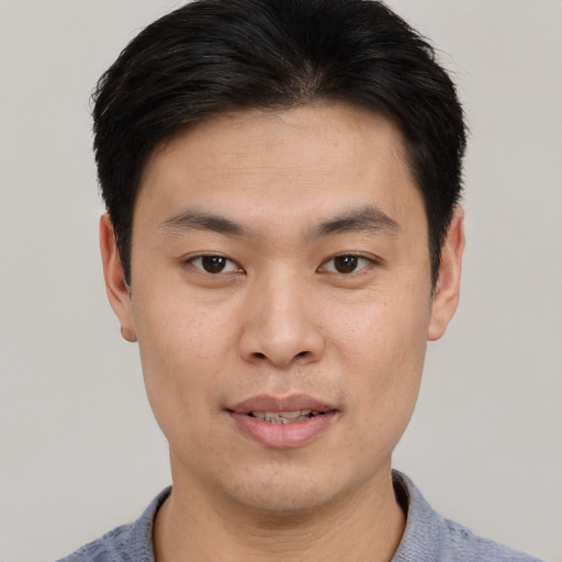 Joyful asian young-adult male with short  brown hair and brown eyes