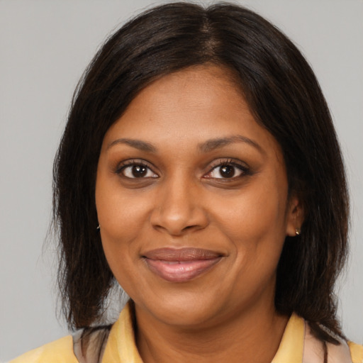 Joyful black young-adult female with medium  brown hair and brown eyes