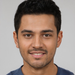 Joyful latino young-adult male with short  brown hair and brown eyes