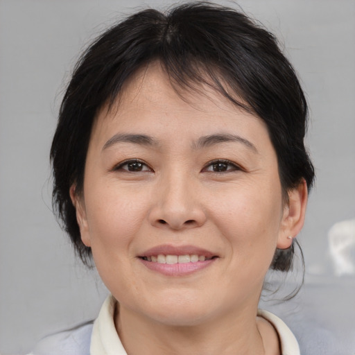Joyful asian adult female with medium  brown hair and brown eyes
