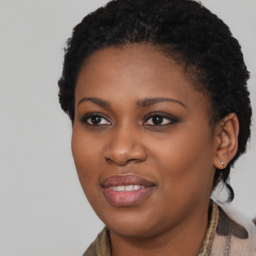 Joyful black young-adult female with short  black hair and brown eyes