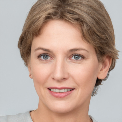 Joyful white adult female with medium  brown hair and grey eyes