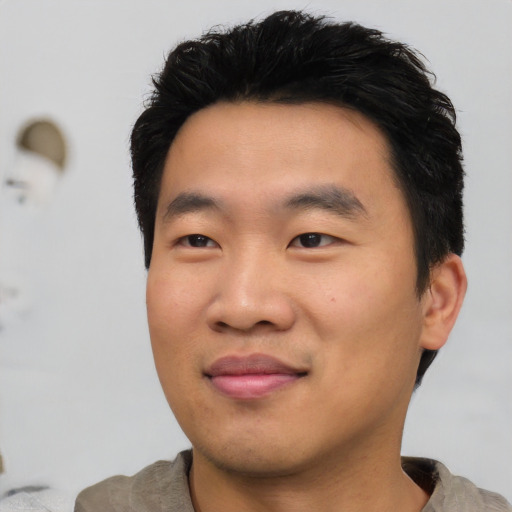 Joyful asian young-adult male with short  black hair and brown eyes