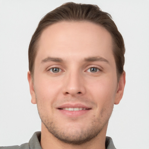 Joyful white young-adult male with short  brown hair and grey eyes