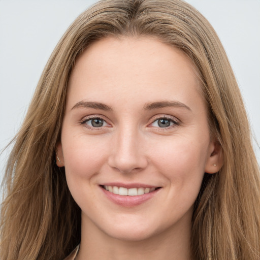 Joyful white young-adult female with long  brown hair and blue eyes